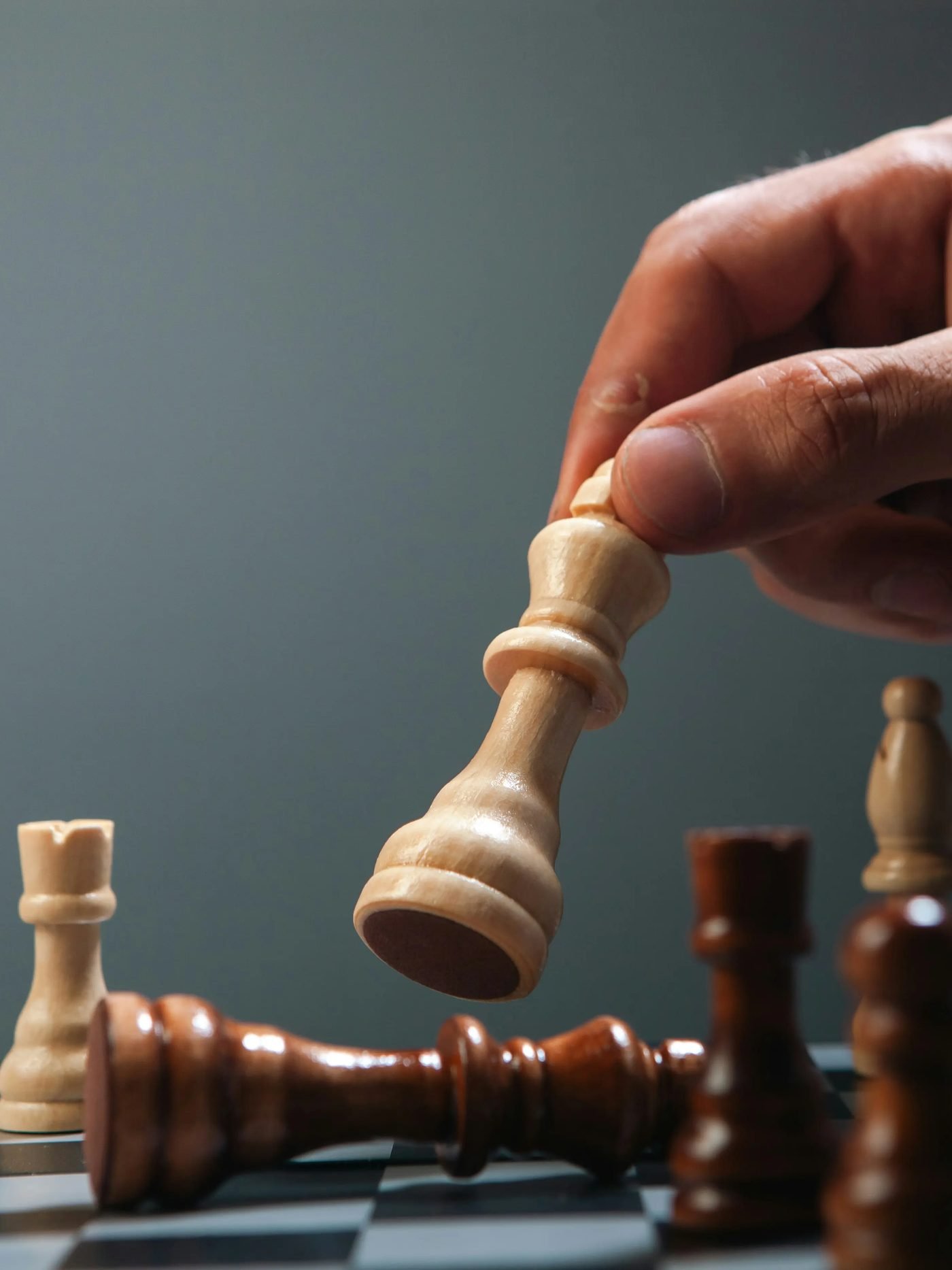 A hand moving a chess piece, representing strategic planning before a transaction