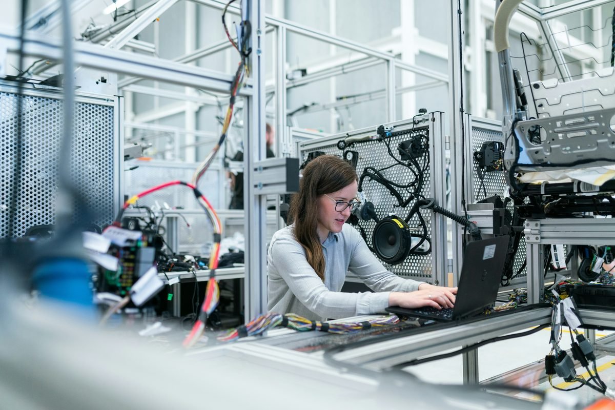 Engineer working on a laptop in a technology manufacturing facility